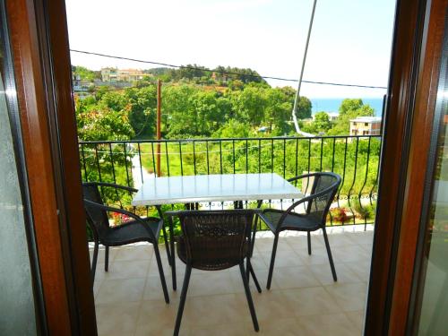 a table and chairs on a balcony with a view at Kandilari Apartments in Kókkinon Nerón