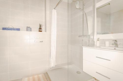 Un baño blanco con ducha y lavabo. en Monte Coast View - Luxe & Pleine Vue Mer - Aux Portes de Monaco, en Beausoleil