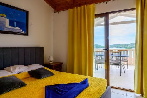 - une chambre avec un lit jaune et un balcon dans l'établissement Villa I Karma, à Tisno
