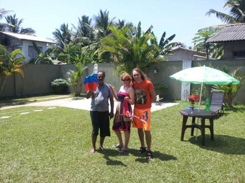 a group of three people standing in a yard at Sunset Beach Residence in Panadura