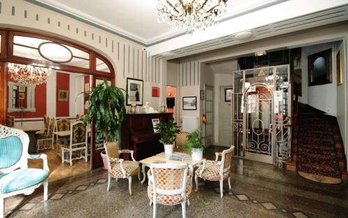 a room with a table and chairs and a chandelier at Hôtel Crystal Reims Centre in Reims
