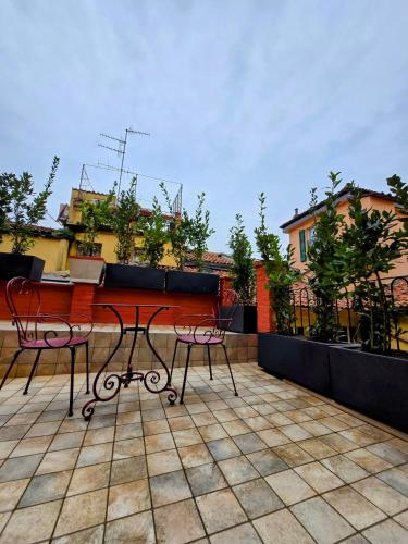 un patio con due sedie e un tavolo sul tetto di Piazza San Martino 9 a Bologna