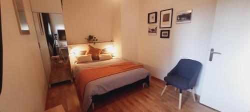 - une petite chambre avec un lit et une chaise bleue dans l'établissement Appartement 3 étoiles au cœur d'Uriage les bains, à Vaulnaveys-le-Haut