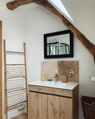 une salle de bain avec un lavabo et un miroir dans l'établissement Le Cellier de Joseph, à Sougéal