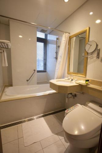 a bathroom with a toilet and a sink and a tub at Rich Garden Hotel in Taipei
