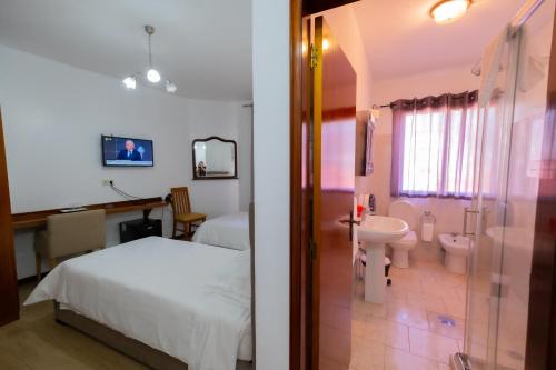 a bedroom with a bed and a bathroom with a sink at Residencial Familia in Machico