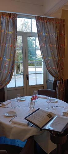 a table with wine glasses on it with a window at Logis Hôtel Restaurant La Vieille Auberge, Art and Gallery in Souillac