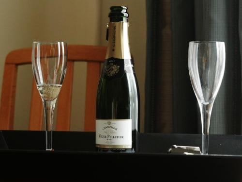 a bottle of wine and two wine glasses on a table at Hôtel Crystal Reims Centre in Reims