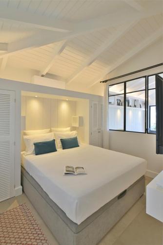 a bedroom with a large white bed with a window at Appartement 2 chambres en plein cœur de St Jean in Saint Barthelemy