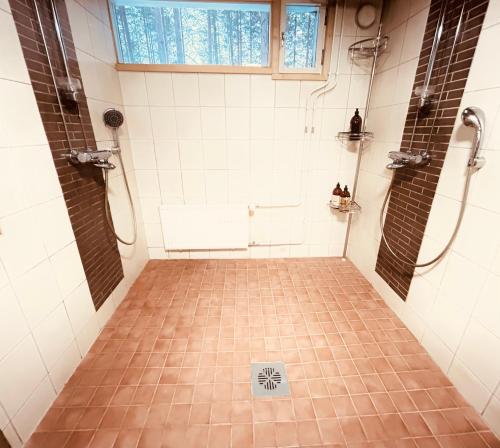 een badkamer met een douche en een tegelvloer bij Kaamos Old House in Rovaniemi