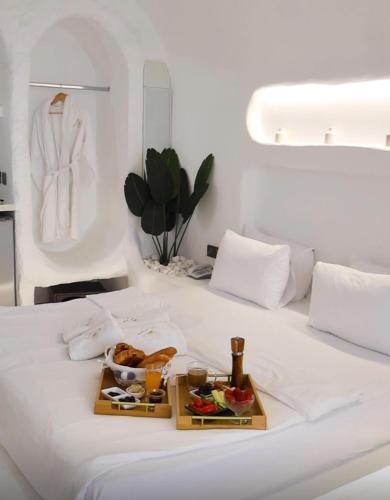 バトゥルーンにあるAqualand Hotel & Resortのベッドの上に食べ物のトレイ