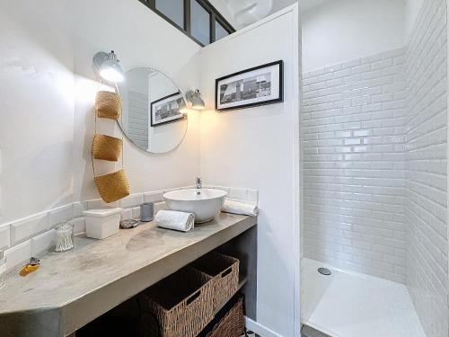 une salle de bain blanche avec un lavabo et un miroir dans l'établissement Le Cocon d'Ange Au Centre 4pers Wifi, à Clermont-Ferrand