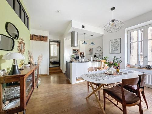 une cuisine et une salle à manger avec une table et des chaises dans l'établissement Le Cocon d'Ange Au Centre 4pers Wifi, à Clermont-Ferrand