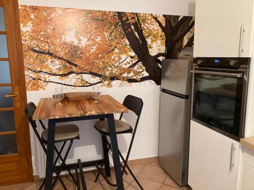 une petite cuisine avec une table et un réfrigérateur dans l'établissement Maison la Douime, à Azerat