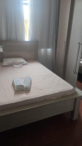 a bed with two towels sitting on top of it at Apartamento para aluguel de temporada, Barbacena in Barbacena