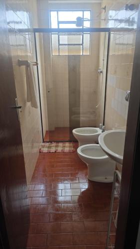 a bathroom with two toilets and a shower at Apartamento para aluguel de temporada, Barbacena in Barbacena