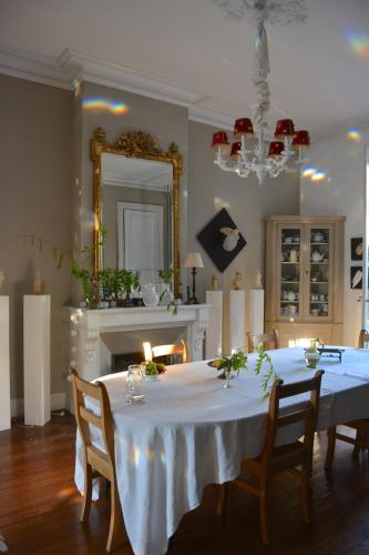 a dining room with a table with chairs and a mirror at la maison in Libourne