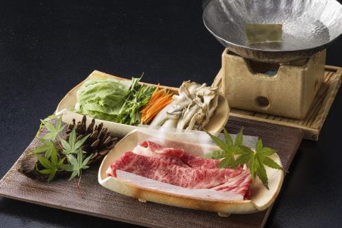 a plate of meat and vegetables on a cutting board at Ichiboukan Hanare Kai in Kyotango