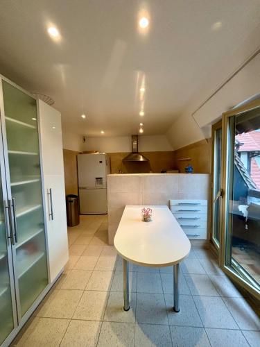 Il comprend une cuisine équipée d'une table blanche et d'un réfrigérateur. dans l'établissement Triangle d Or, à Deauville