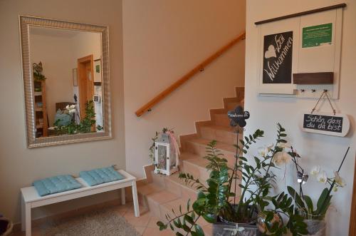 a hallway with stairs and a mirror and plants at Landhaus Aigner in Allhartsberg
