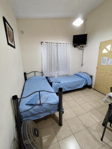 a room with two beds and a fan and a window at Cabañas Margus in La Granja