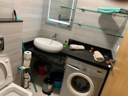 a bathroom with a washing machine and a sink at La location de la mer in Dar Bouazza