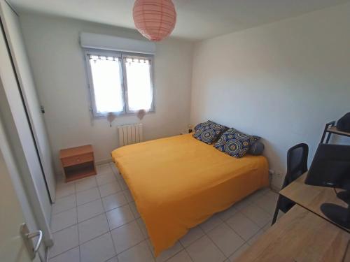een slaapkamer met een geel bed en een raam bij Appartement in Digne-les-Bains