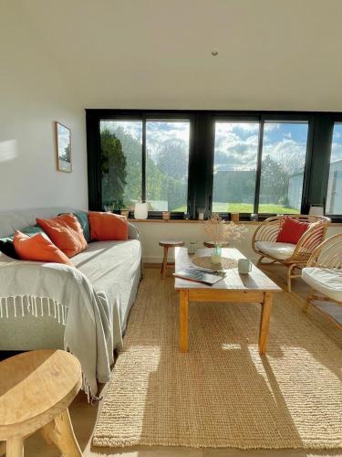 un salon avec un canapé et une table dans l'établissement Kerlud, maison avec garden, à Locmariaquer