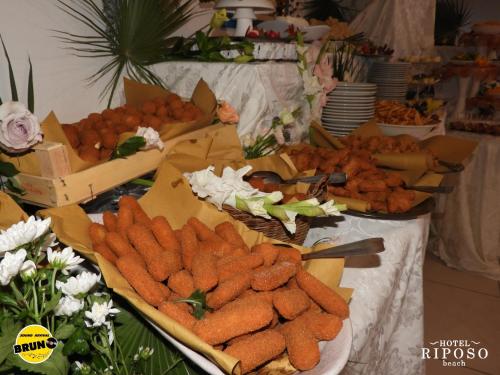 a buffet with carrots and other food on a table at Hotel Riposo in Gatteo a Mare