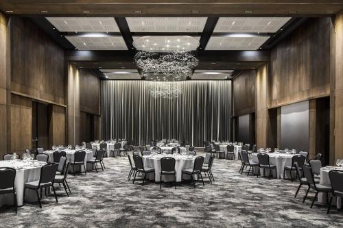 a banquet hall with tables and chairs and a chandelier at Marriott Executive Apartments Johannesburg, Melrose Arch in Johannesburg