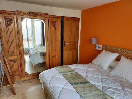 une chambre avec un lit avec un mur orange dans l'établissement Appartement duplex avec cour extérieure Avignon centre, à Avignon