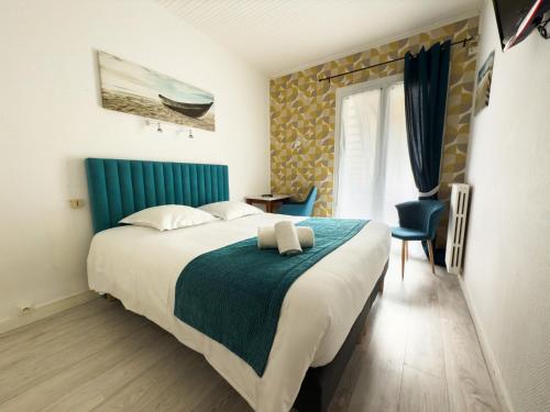 a bedroom with a large bed with a blue headboard at Hotel de Paris in La Rochelle