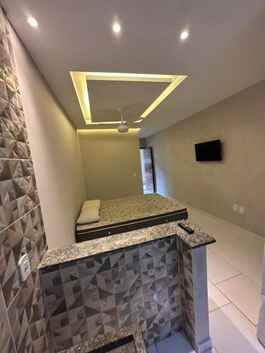 Una habitación con una cama y un televisor en el techo. en Arraial Hospedagem, en Arraial do Cabo