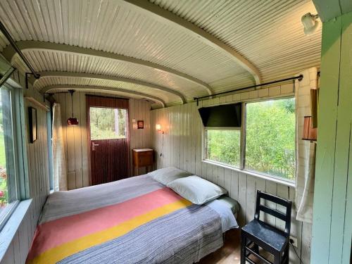 a bedroom in a train car with a bed in it at Wooden Cabin - Outdoor Kitchen - Superb Location! in Capdrot