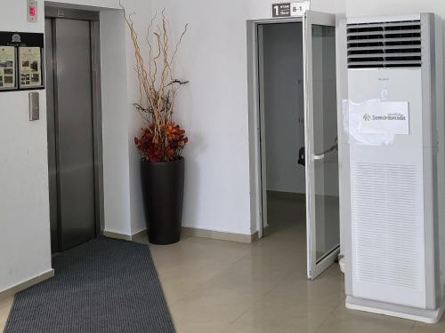 a hallway with a door and a vase with a plant at Pinewood ANG premium luxurious apartment 15 in Borovets
