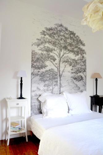 a bedroom with a tree mural on the wall at la maison in Libourne