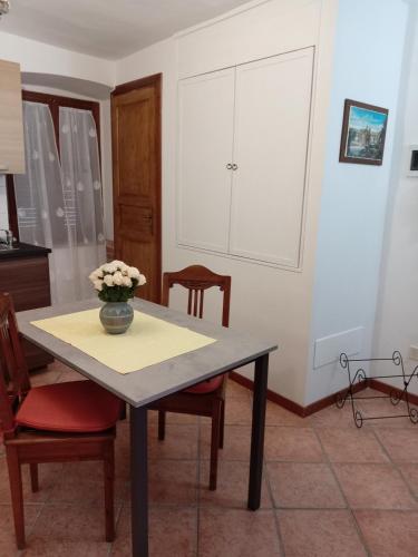 a kitchen with a table with a vase of flowers on it at Casa VACANZE LUSITANA C2 in Foligno