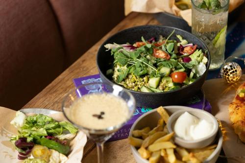 a table topped with a salad and a bowl of dip at Moxy Glasgow Merchant City in Glasgow