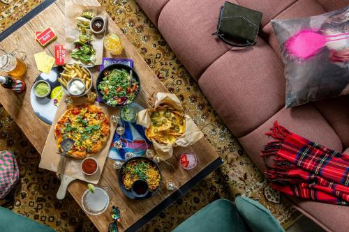 a table topped with plates of food on top of a couch at Moxy Glasgow Merchant City in Glasgow