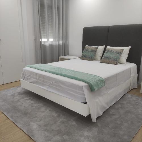 a bedroom with a large white bed with pillows at Lima Zen - Guest House in Ponte de Lima