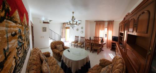 ein Wohnzimmer mit Sofas und einem Tisch sowie ein Esszimmer in der Unterkunft La Casa de las Golondrinas in Santisteban del Puerto