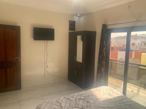 a bedroom with a flat screen tv on the wall at Appartement meublé sacré cœur 3 deux chambres salon in Dakar