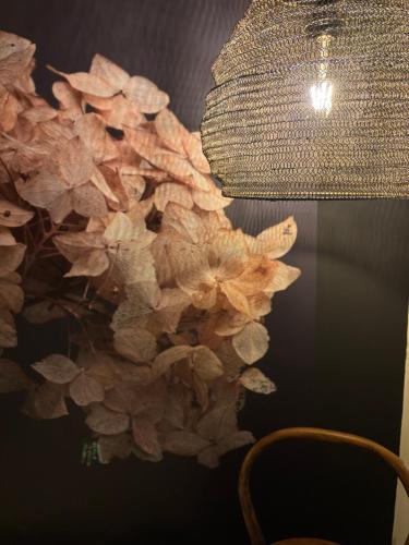 a chandelier and a vase of flowers on a wall at LUZZ me - Casa das Doze Ribeiras in Doze Ribeiras