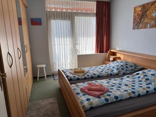 a bedroom with two twin beds and a window at Waldblick - Bad Harzburg - Schwimmbad und Sauna in Bad Harzburg