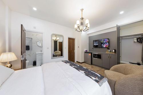 a bedroom with a large white bed and a chandelier at Apple Tree House 2 in Ilford