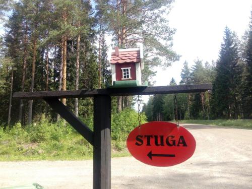a small bird house on a wooden pole with a sign at The hunters-lodge in Ludvika