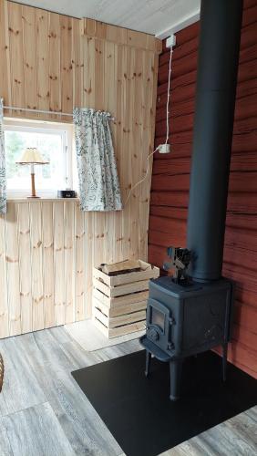 a room with a stove in a room with wooden walls at The hunters-lodge in Ludvika