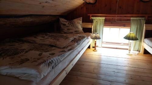 a bed in a wooden room with a window at The hunters-lodge in Ludvika