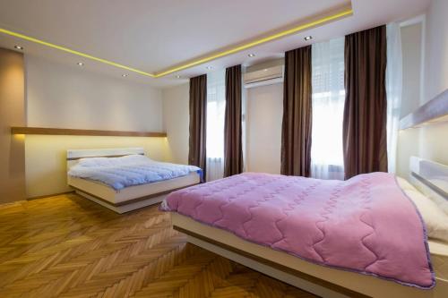 a bedroom with two beds and a large window at Central Apartments in Belgrade
