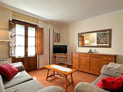 a living room with a couch and a tv at Casa Rural Las Condesas in Santo Domingo de Silos